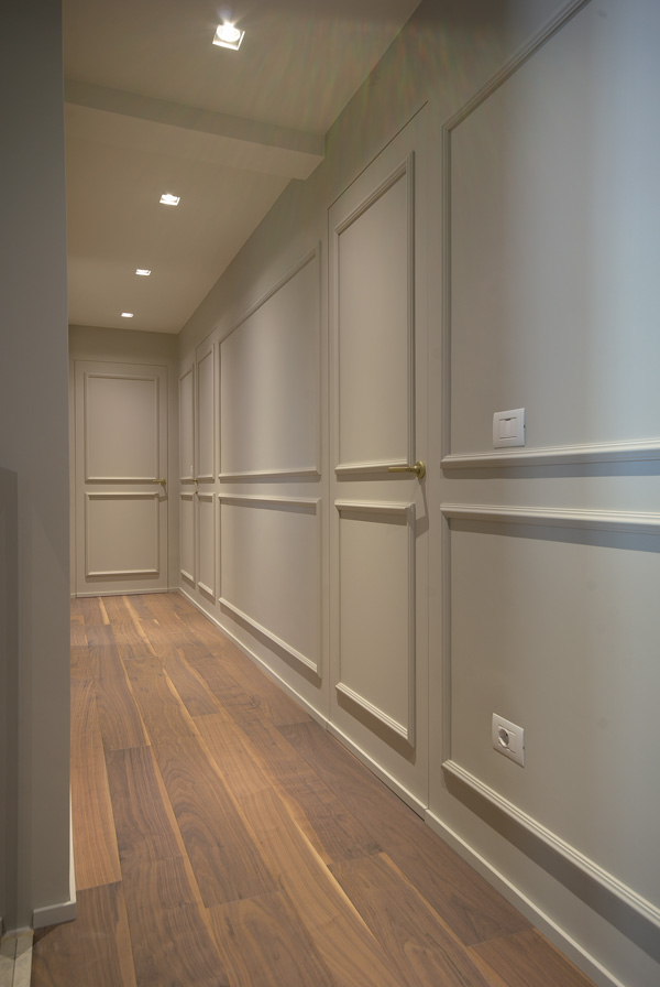 Corridoio elegante con pareti bicolore e pavimento in legno.