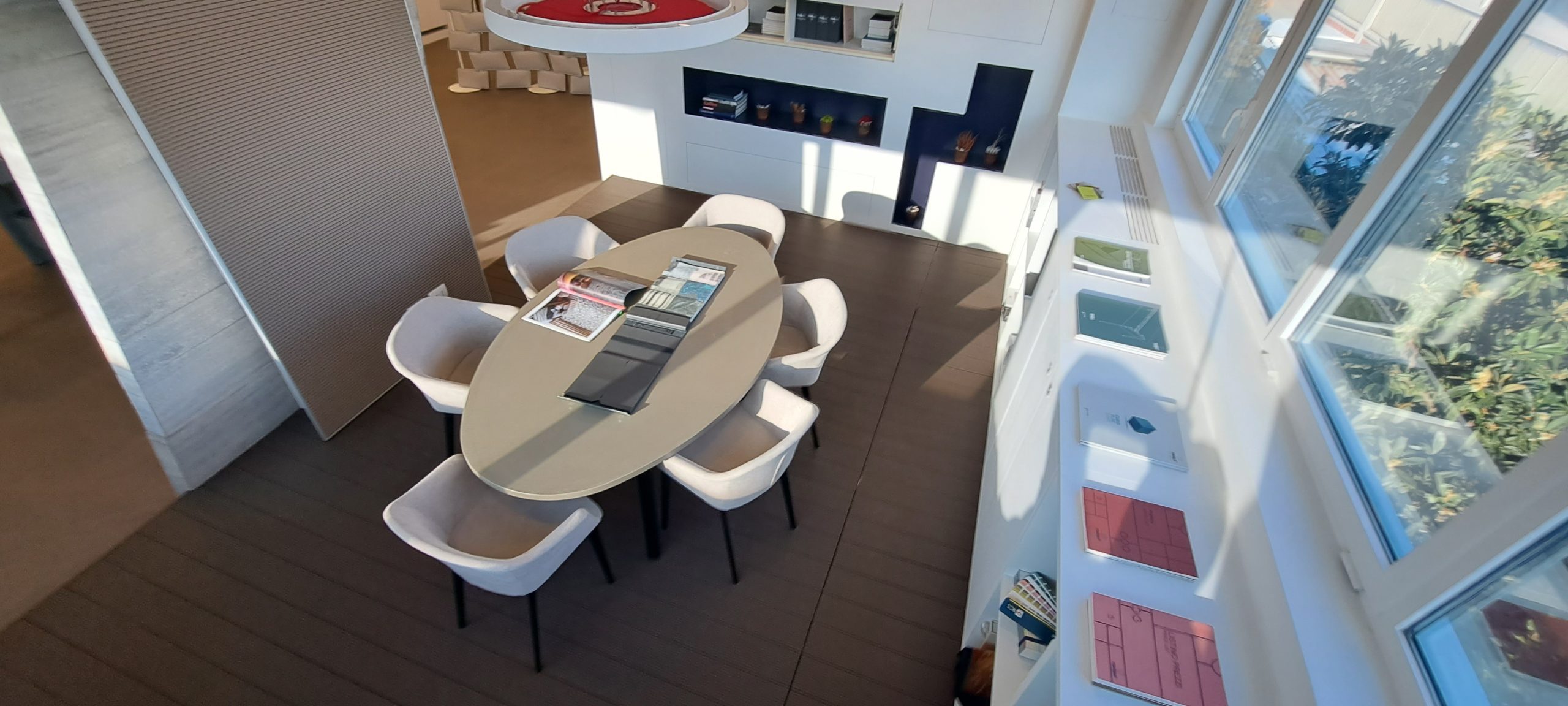 Sala moderna con tavolo ovale e sedie eleganti.