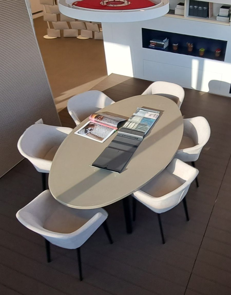 Sala riunioni moderna con tavolo ovale e sedie eleganti.