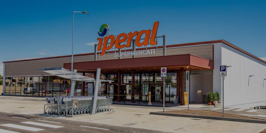 Supermercato Iperal esterno con carrelli e parcheggio.