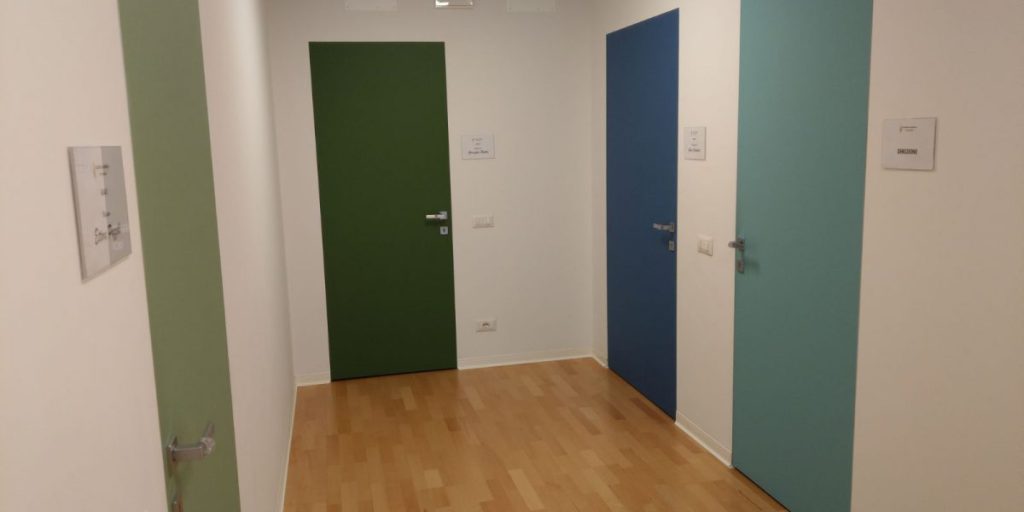 Corridoio con porte colorate in ufficio moderno.