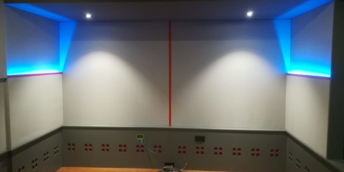 Sala con illuminazione a LED blu e parete rossa.