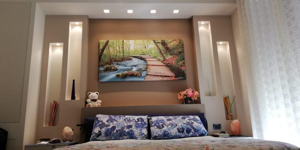 Camera da letto accogliente con quadro di paesaggio fluviale.