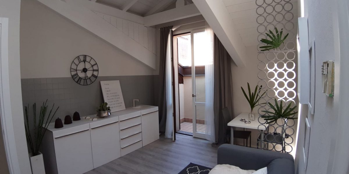 Interno moderno soggiorno minimalista con dettagli decorativi.
